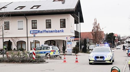 Einsatzkräfte der Polizei stehen nach einem Überfall auf einen Geldtransporter in der Nähe einer Bank . / Foto: Josef Reisner/dpa