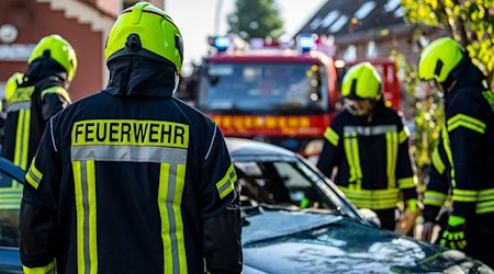 Feuerwehrleute stehen um ein Auto, das einen Unfall gehabt hat. / Foto: David Inderlied/dpa/Symbolbild