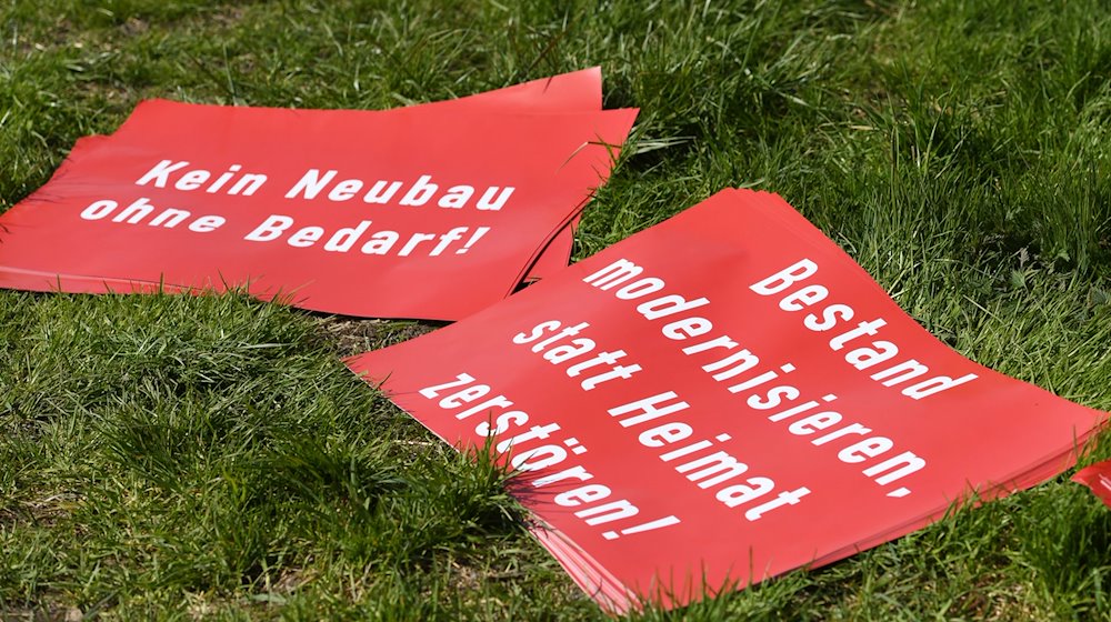 Protestplakate, gegen den Brenner-Nordzulauf im Inntal, mit der Aufschrift «Kein Neubau ohne Bedarf!» und «Bestand modernisieren, statt Heimat zerstören!» liegen auf einer Wiese. / Foto: Angelika Warmuth/dpa