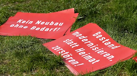 Protestplakate, gegen den Brenner-Nordzulauf im Inntal, mit der Aufschrift «Kein Neubau ohne Bedarf!» und «Bestand modernisieren, statt Heimat zerstören!» liegen auf einer Wiese. / Foto: Angelika Warmuth/dpa