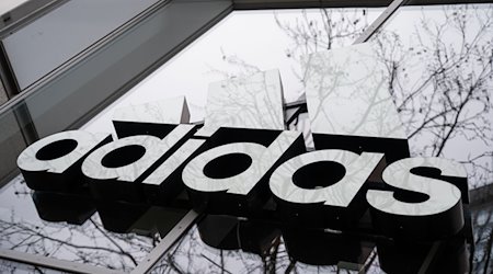 Der Schriftzug von Adidas an der Fassade eines Lokals. / Foto: Christophe Gateau/dpa