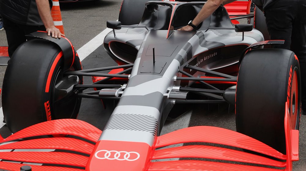 Teammitglieder schieben den neuen Rennwagen von Audi auf der Rennstrecke Spa-Francorchamps. / Foto: Olivier Matthys/AP/dpa