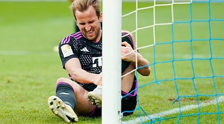 Harry Kane von München sitzt mit schmerzverzerrtem Gesicht auf dem Rasen. / Foto: Uwe Anspach/dpa