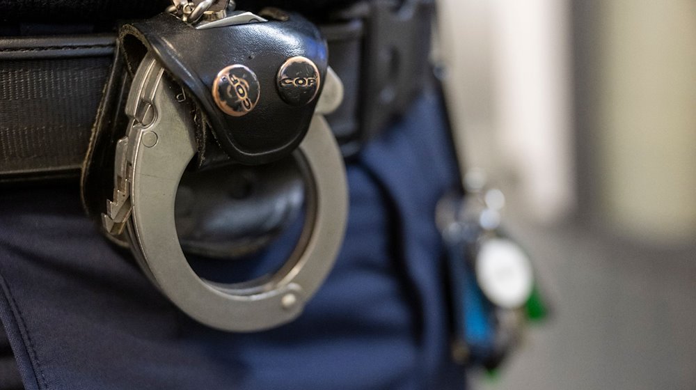 Eine Handschelle hängt am Gürtel eines Polizisten der Polizeiinspektion 11. / Foto: Peter Kneffel/dpa