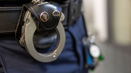 Eine Handschelle hängt am Gürtel eines Polizisten der Polizeiinspektion 11. / Foto: Peter Kneffel/dpa