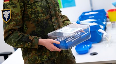 Eine Soldatin der Bundeswehr trägt im Impfzentrum eine Kiste mit Spritzen gegen das Coronavirus (Biontech). / Foto: Sven Hoppe/dpa/Archivbild