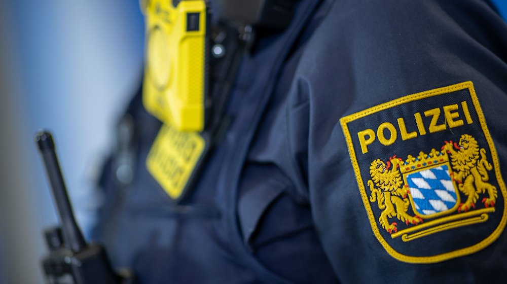 Eine Polizistin trägt ein Abzeichen der bayerischen Polizei. / Foto: Daniel Karmann/dpa/Symbolbild