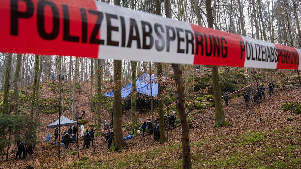 Polizisten suchen ein Gebiet im Wald ab, in dem zuvor Knochen der vermissten Sonja Engelbrecht in einer Felsspalte gefunden worden waren. / Foto: Peter Kneffel/dpa