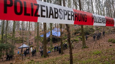 Polizisten suchen ein Gebiet im Wald ab, in dem zuvor Knochen der vermissten Sonja Engelbrecht in einer Felsspalte gefunden worden waren. / Foto: Peter Kneffel/dpa