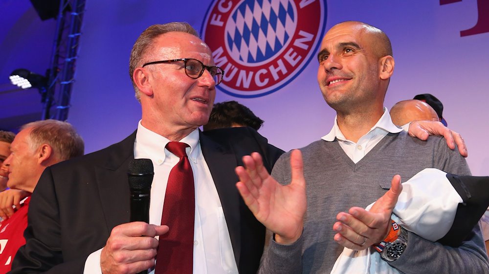 Karl-Heinz Rummenigge (l) Vorstandsvorsitzender des FC Bayern München unterhält sich am 21.05.2016 bei der Meisterfeier des FC mit Trainer Pep Guardiola. / Foto: Alexander Hassenstein / Pool/epa/dpa/Archivbild
