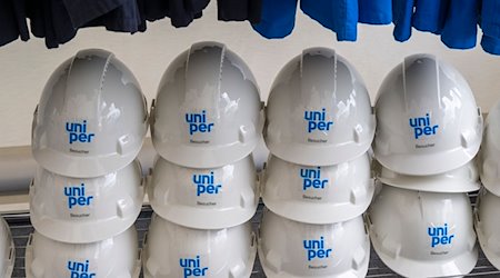 Helme mit der Aufschrift «Uniper» stehen während der Vorstellung des neuen Wasserstoffspeicher-Projekts HyStorage in Bierwang in einem Schrank. / Foto: Peter Kneffel/dpa