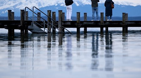 Menschen stehen auf einem Steg am Starnberger See. / Foto: Sven Hoppe/dpa