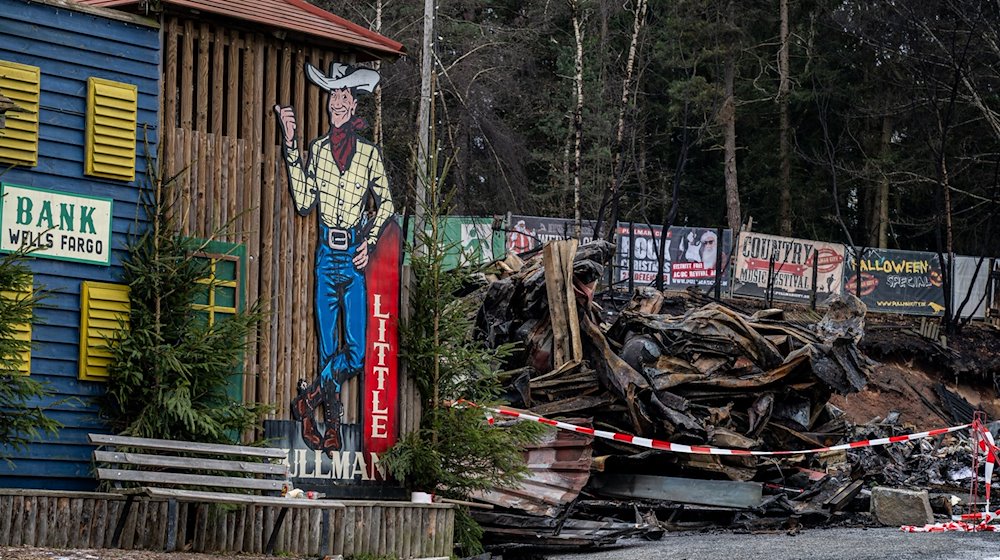 Trümmer liegen nach einem Großbrand auf dem Gelände der Westernstadt «Pullman City». / Foto: Armin Weigel/dpa