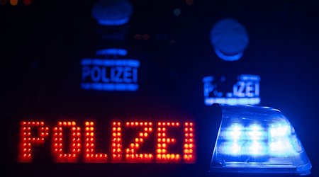 Zwei Polizisten stehen vor einem Streifenwagen. / Foto: Marijan Murat/dpa/Symbolbild