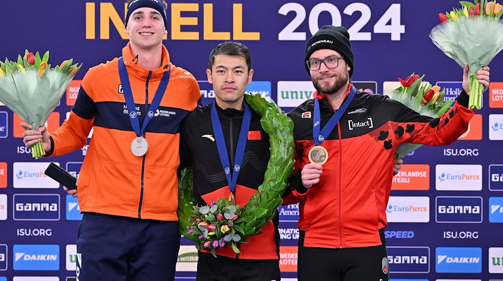 Eisschnelllauf: Sprint-Weltmeisterschaft - Siegerehrung Herren Gesamtwertung Sprint. Jenning De Boo (l-r) aus den Niederlanden, 2. Platz, Zhongyan Ning aus China, 1. Platz, und Laurent Dubreuil aus Kanada, 3. Platz, stehen auf dem Podium. / Foto: Peter Kneffel/dpa