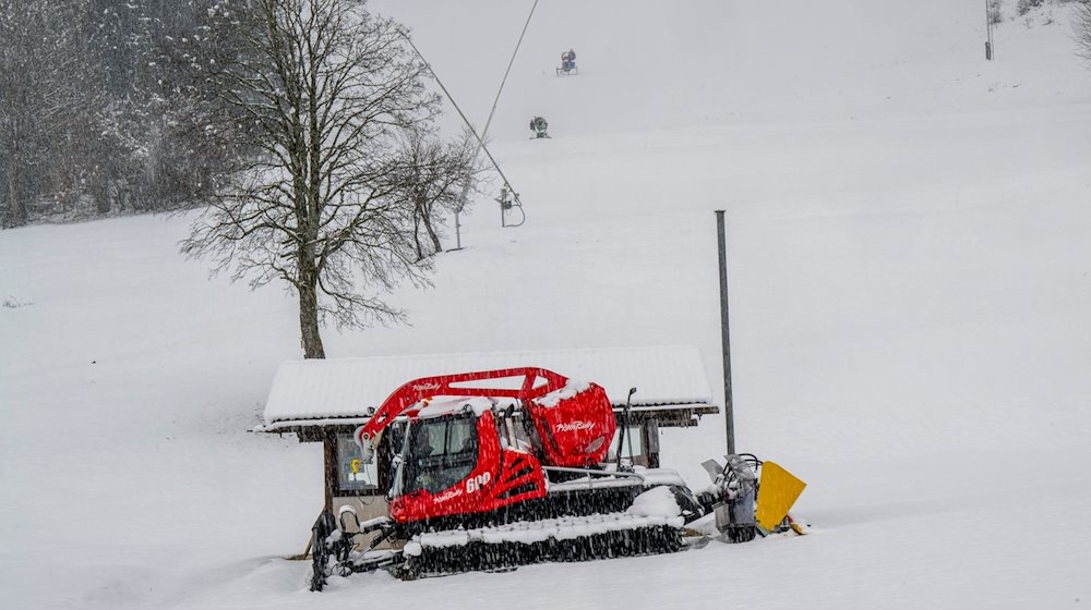 Ein Pistenbully steht am Kassenhäuschen der zur zeit stillgelegten Skiliftanlage Steckenberg. / Foto: Peter Kneffel/dpa