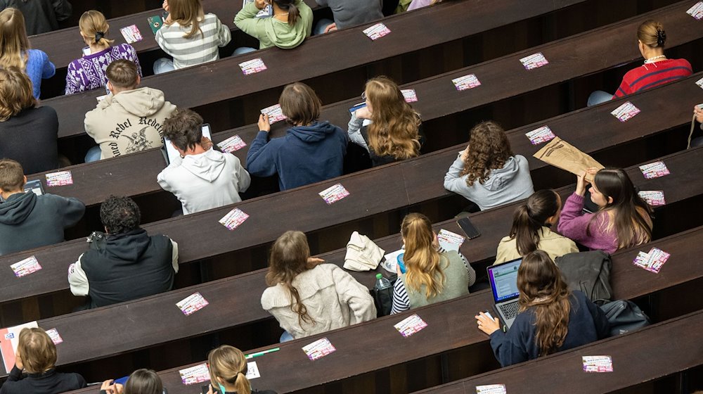 Studenten nehmen an der Einführungsveranstaltung im Audimax der Ludwig-Maximilians-Universität teil. / Foto: Peter Kneffel/dpa