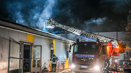 Einsatzkräfte der Feuerwehr löschen einen Brand in einer Asylbewerberunterkunft. / Foto: Marius Bulling/dpa