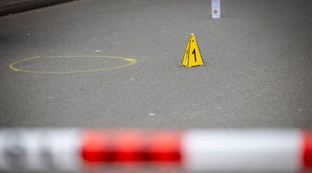 Markierungen der Spurensicherung auf dem Boden am Tatort des Angriffs auf zwei Kinder, einige Meter von einer Schule entfernt. Auf einem kleinen Parkplatz hat die Polizei Flatterband gespannt und alles abgesperrt. / Foto: Christoph Reichwein/dpa