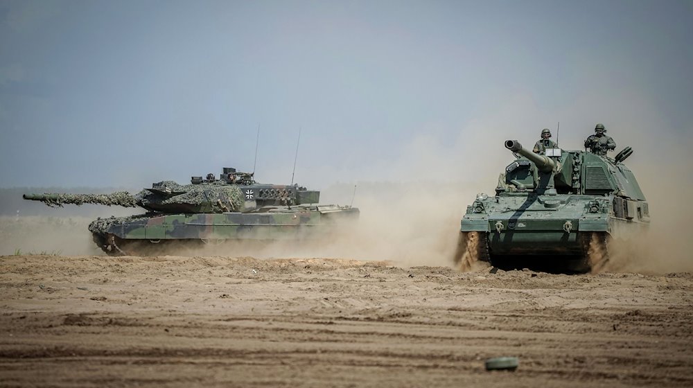 Eine Panzerhaubitze 2000 (r) und ein Leopard 2 Kampfpanzer bei der Nato-Übung «Griffin Storm». / Foto: Kay Nietfeld/dpa