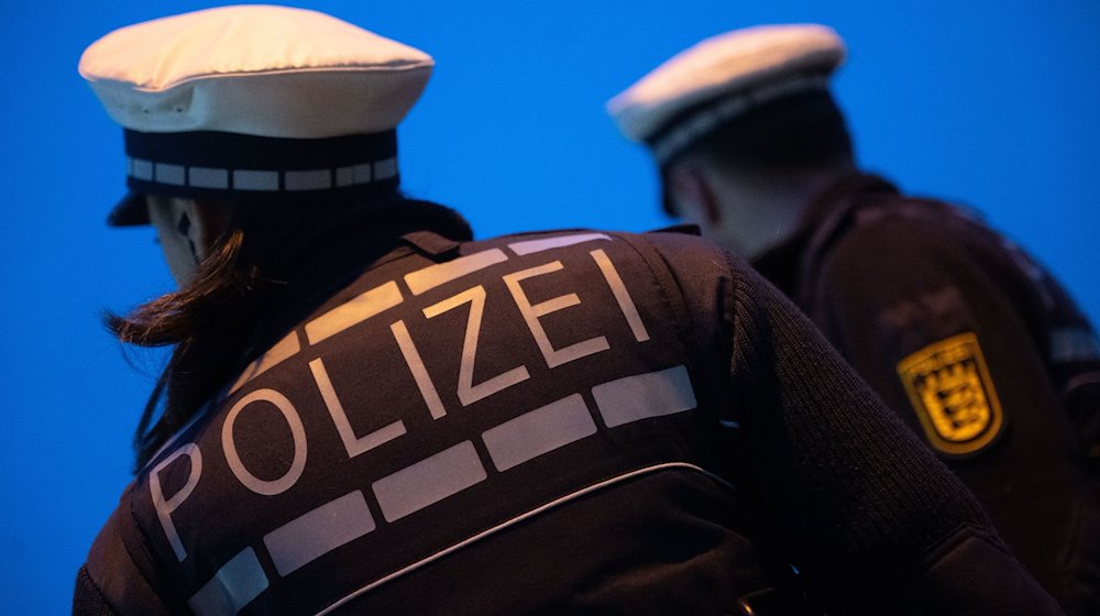 Zwei Polizeibeamte in Uniform. Ein Mann soll in einer Sauna Gäste angepöbelt und zwei Polizisten verletzt haben. / Foto: Marijan Murat/dpa/Symbolbild