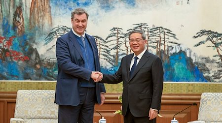 Markus Söder, (l, CSU) Ministerpräsident von Bayern, wird in Peking von LI Qiang (r), Premierminister der Volksrepublik China, empfangen. / Foto: Peter Kneffel/dpa