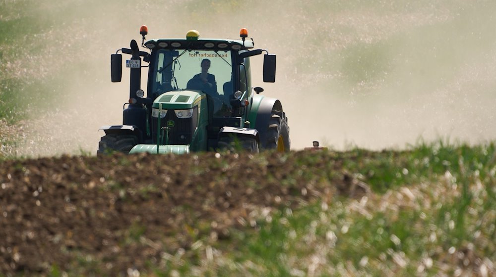 Ein Traktor bearbeitet mit der Scheibenegge ein Feld. / Foto: Thomas Frey/dpa