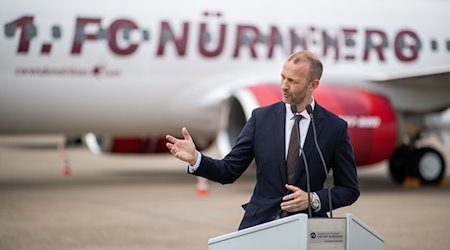 Niels Rossow, Kaufmännischer Vorstand des 1. FC Nürnberg, spricht auf dem Vorfeld des Flughafens. / Foto: Daniel Karmann/dpa/Archivbild