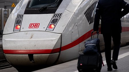Ein Mitarbeiter der Deutschen Bahn (DB) geht am Hauptbahnhof zu einem Zug. / Foto: Sven Hoppe/dpa