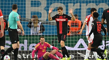 Leverkusens Josip Stanisic (M) wehrt nach seinem Tor zum 1:0 Jubelgesten ab. / Foto: Federico Gambarini/dpa