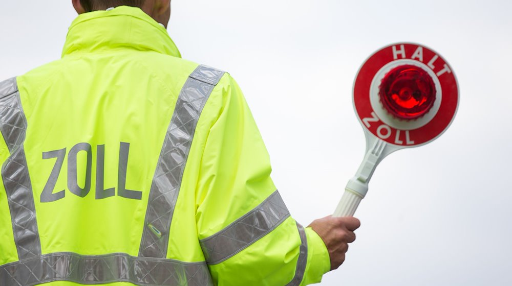 Ein Zollbeamter hält eine Kelle. / Foto: Friso Gentsch/dpa/Symbolbild