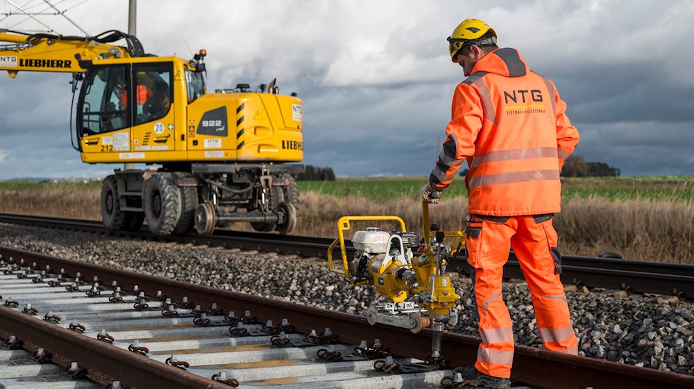 Ein Arbeiter verschraubt das Gleis mit Betonschwellen an der Bahnbaustelle der ICE-Strecke zwischen Nürnberg und Bamberg. / Foto: Daniel Vogl/dpa/Symbolbild