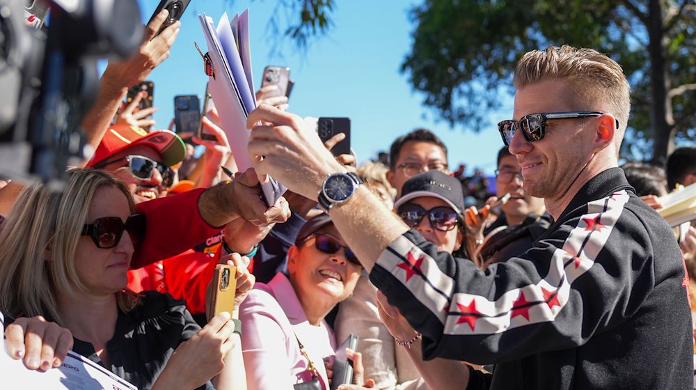Der deutsche Haas-Pilot Nico Hülkenberg schreibt Autogramme für Fans, als er vor dem Großen Preis von Australien auf dem Albert Park Circuit eintrifft. / Foto: Asanka Brendon Ratnayake/AP/dpa