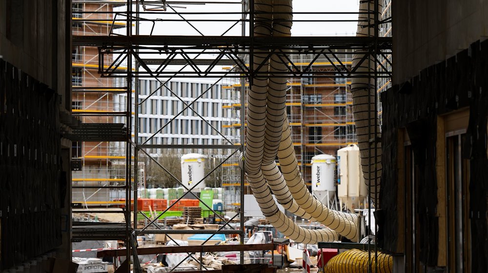 Ein Gerüst und Baumaterial sind auf der Baustelle eines Neubaus zu sehen. / Foto: Sven Hoppe/dpa