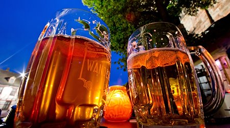 Zwei Krüge mit Bier stehen zur blauen Stunde am Abend des 02.07.2013 in Nürnberg (Bayern) auf dem Tisch eines Gasthauses. / Foto: Daniel Karmann/dpa