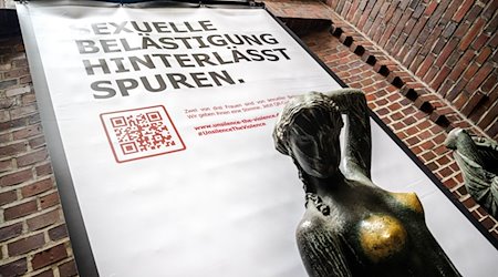Ein Plakat mit der Aufschrift „Sexuelle Belästigung hinterlässt Spuren“ hängt hinter der Bronzeskulptur „Jugend“ des Künstlers Bernhard Hoetger. / Foto: Sina Schuldt/dpa/Archivbild