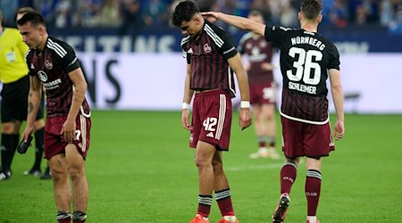 Jens Castrop, Can Uzun und Lukas Schleimer (l-r) von Nürnberg zeigen sich nach dem Spiel enttäuscht. / Foto: Bernd Thissen/dpa