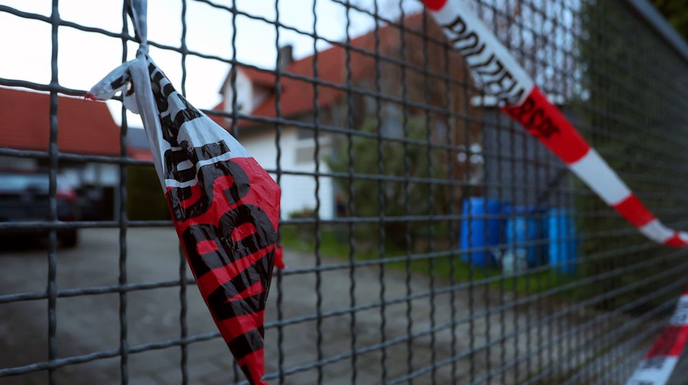 Ein Absperrband der Polizei hängt am Hoftor eines Einfamilienhauses in Altenstadt. / Foto: Karl-Josef Hildenbrand/dpa/Archivbild
