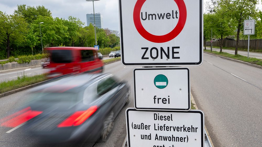 Straßenschilder mit der Aufschrift «Umwelt Zone» und «Diesel (außer Lieferverkehr und Anwohner) erst ab Euro 5/V frei» hängen zwischen den Strassen am Münchner Ring. / Foto: Peter Kneffel/dpa
