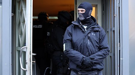 Einsatzkräfte der Polizei stehen bei einer Razzia im Eingangsbereich eines Gebäudes. / Foto: Gianni Gattus/Blaulicht Aktuell Solingen/dpa