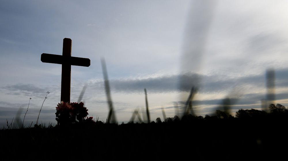 Ein Kreuz zum Gedenken an ein Opfer eines Verkehrsunfalls steht an einer Landstraße. / Foto: Julian Stratenschulte/dpa/Archivbild