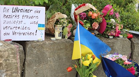 Am Gelände eines Einkaufszentrums, an dem am Samstagabend (27.04.2024) zwei Männer aus der Ukraine getötet worden sind, wurden Blumen niedergelegt, sowie eine kleine ukrainische Flagge aufgestellt. / Foto: Constanze Wilz/dpa