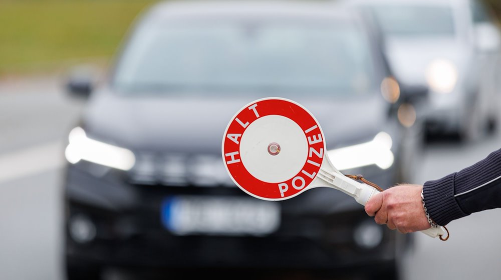 Ein Beamter der Bundespolizei stoppt bei der kontrolle des Einreiseverkehrs am deutsch-tschechischen Grenzübergang ein Auto. / Foto: Daniel Karmann/dpa/Archivbild