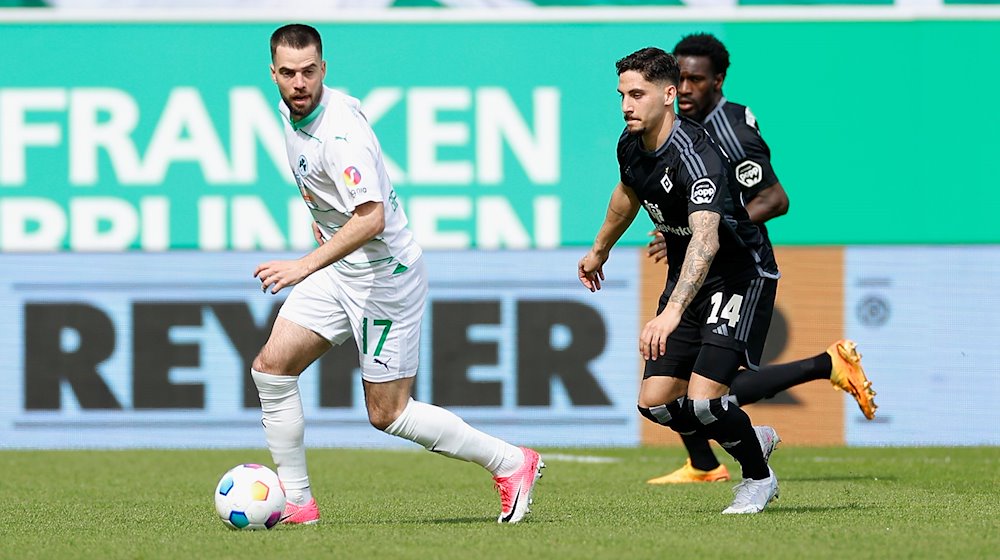 Thomas Sommer, Niko Gießelmann (SpVgg Greuther Füerth, 17) im Laufduell mit Ludovit Reis (Hamburger SV, 14). / Foto: Heiko Becker/dpa