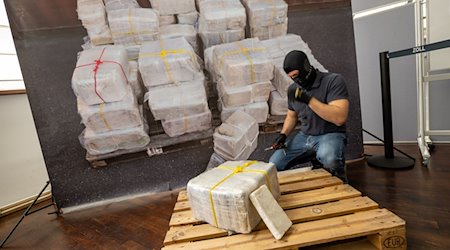 Ein Zollbeamter kniet vor einem Teil der zur bislang größten Einzelsicherstellung von Kokain in Bayern. / Foto: Peter Kneffel/dpa