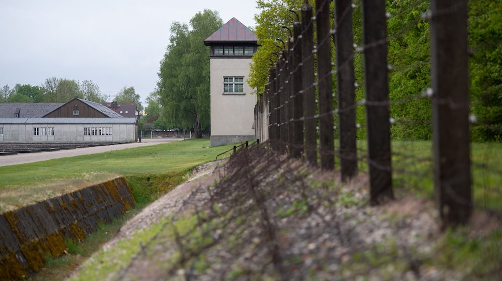 Ein Zaun und ein Wachturm sind an der Gedenkstätte des Konzentrationslagers Dachau zu sehen. / Foto: Sven Hoppe/dpa