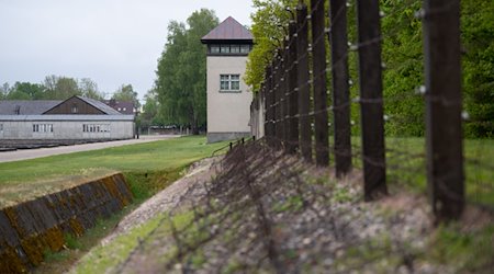 Ein Zaun und ein Wachturm sind an der Gedenkstätte des Konzentrationslagers Dachau zu sehen. / Foto: Sven Hoppe/dpa