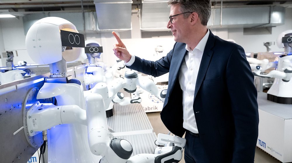 Markus Blume (CSU), Wissenschaftsminister von Bayern, schaut sich während der KI-Konferenz "AI.BAY 2023" in der KI.Fabrik des Munich Institute of Robotics and Machine Intelligence (MIRMI) der Technischen Universität München (TUM) die Roboter an. / Foto: Sven Hoppe/dpa