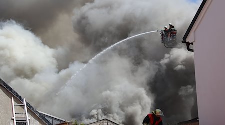 Einsatzkräfte der Feuerwehr versuchen den Brand im Dachstuhl einer Lagerhalle zu löschen. / Foto: Masching/NEWS5/dpa