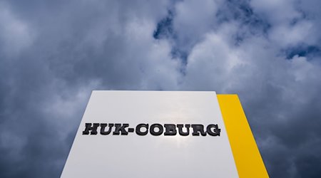 Auf einem Schild ist der Schriftzug des Unternehmens HUK-Coburg angebracht. / Foto: Nicolas Armer/dpa